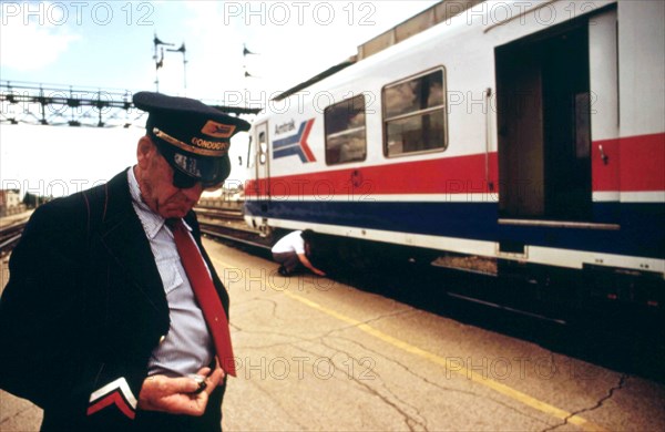 Conductor checks his watch, Bloomington, Illinois, stop on the turboliner run between St. Louis, Missouri, and Chicago, June 1974