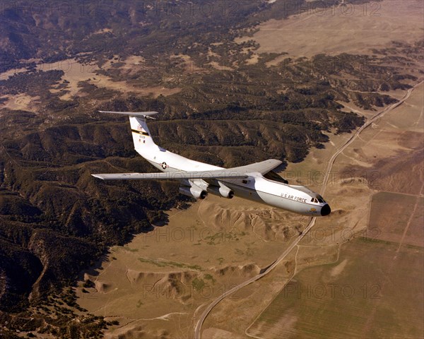 An air-to-air left side view of a C-141 Starlifter aircraft