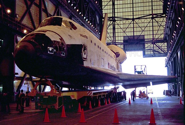 Carried atop an orbiter transporter, the Space Shuttle orbiter Atlantis rolls into the transfer aisle of the Vehicle Assembly Building (VAB) ca. 1997