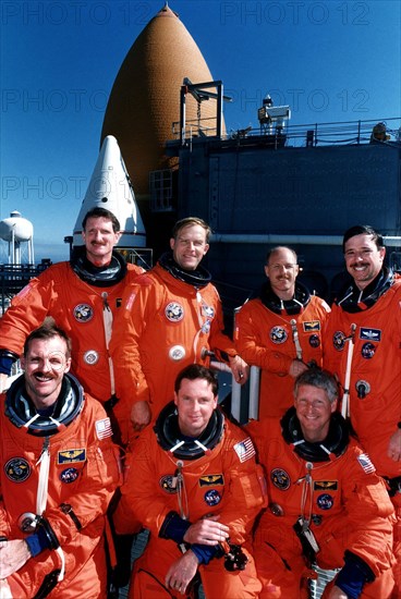 STS-82 crew members are all smiles as they pose for a group photo at Launch Pad 39A in front of the Space Shuttle Discovery ca. 1997