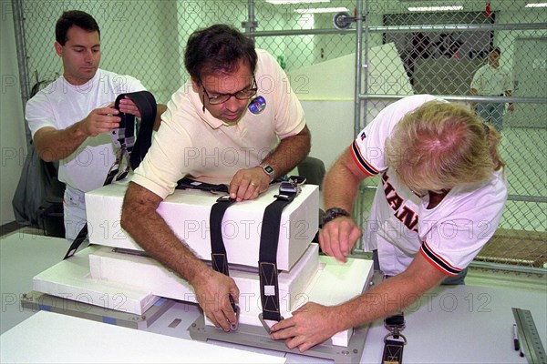 Boeing technicians, from right, John Pearce Jr., Mike Vawter and Rob Ferraro prepare a Russian replacement computer for stowage aboard the Space Shuttle Atlantis ca. 1997
