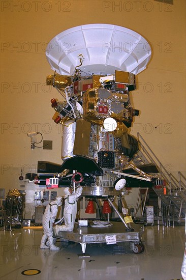 Jet Propulsion Laboratory (JPL) worker Mary Reaves mates connectors on a radioisotope thermoelectric generator (RTG) to power up the Cassini spacecraft, while quality assurance engineer Peter Sorci looks on ca. 1997