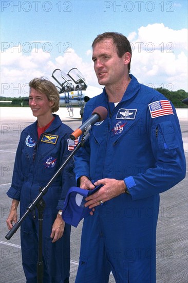 STS-94 Pilot Susan Leigh Still watches as Commander James D. Halsell, Jr., speaks to the media after the crew arrived at the Shuttle Landing Facility at Kennedy Space Center  ca. 1997