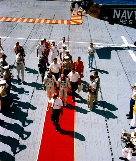 (29 Aug. 1965) --- Astronauts L. Gordon Cooper Jr. (right center), Gemini-Titan 5 and Charles Conrad Jr., pilot, receive a red-carpet welcome as they arrive aboard the aircraft carrier USS Lake Champlian