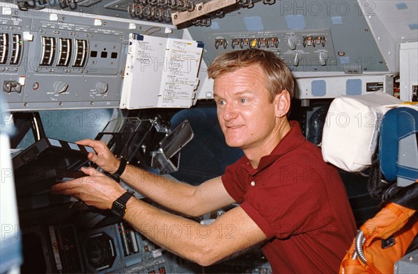 1990 STS-36 Pilot Casper reaches for laptop computer on OV-104's flight deck