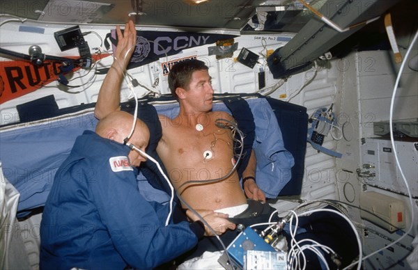 (24 Nov-1 Dec 1991) --- Astronaut F. Story Musgrave (left), Mission Specialist, assists Astronaut Terence T. (Tom) Henricks, Mission Specialist, with a Detailed Supplementary Objective (DSO) involving Lower Body Negative Pressure.