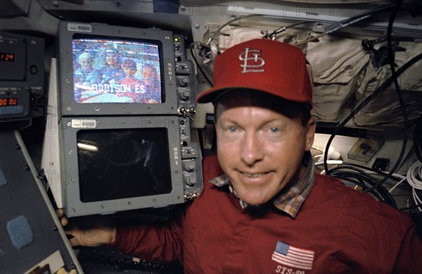 Crewmember and video monitor during combined video and SAREX broadcast.