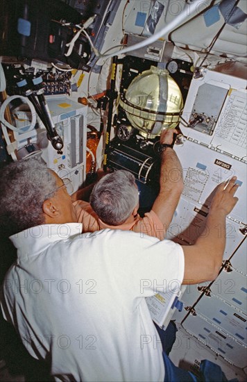 Crewmembers in the middeck with the FARE experiment.