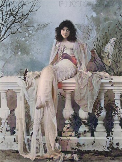 beautiful woman with veil sits on a balustrade on the terrace