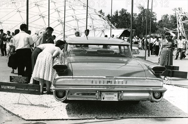 Interested spectators look inside an Oldsmobile, 1959