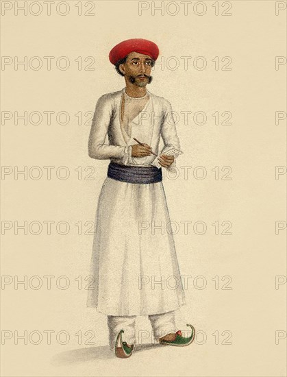 Hindu man stands in white tunic over white trousers