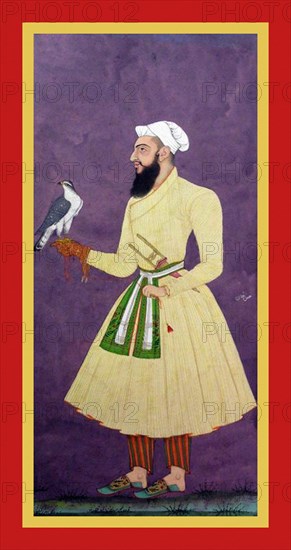 ?asan Khan stands against purple background