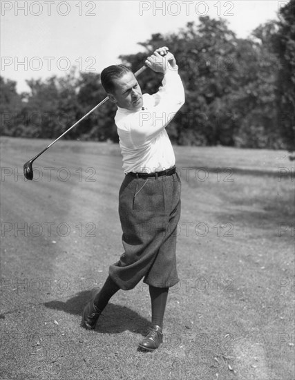 Robert T. (Bobby) Jones making a practice shot on a fairway. March, 1936.