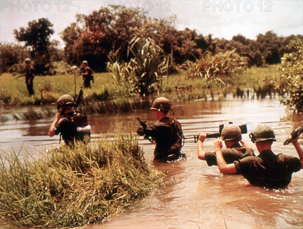 16th Armored Division members cross a jungle river in previous Viet Cong territory. Vietnam, 9/65.