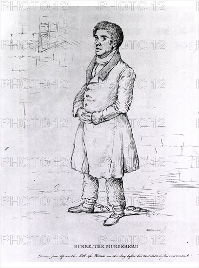 Full length view of Burke, in a prison cell, wearing leg irons.