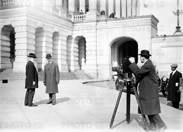 Photographer taking pictures of posed politicians