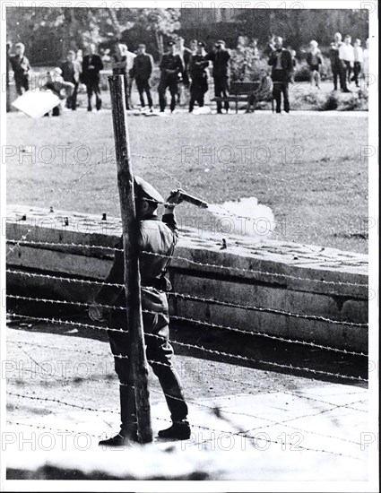 October 1961 - Communist 'People's Policemen' (Volkspolizist), Standing Between the Border Fence and Wall, Prepares to Throw a Tear-Gas Grenade at a Group of West Berliners Who Gathered On Their Side of the Border to Jeer the Red Guards