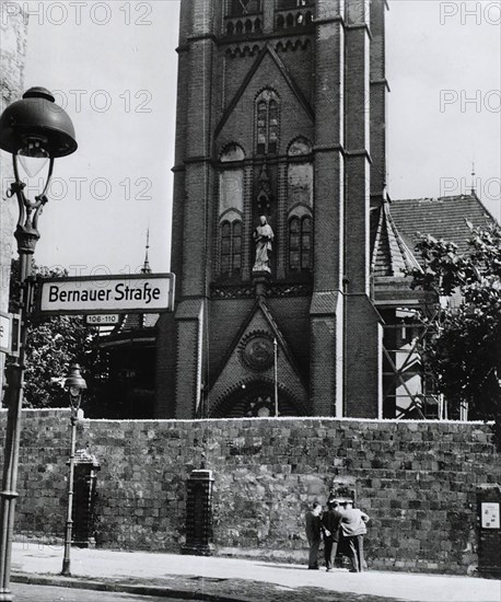 Berlin Wall along Bernauer Street blocks entrance to church in East Berlin symbolically reminding Germans of Communist opposition to religion.