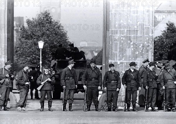 August 1961 - A Squad of East Berlin 'Workers' Militia' With Submachine Guns Stands Shoulder-To-Shoulder in Front of the Brandenburg Gate. Behind Them, Blocking the Passageway, Is A Communist Armored Car