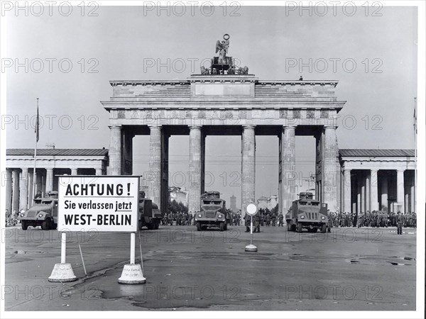 Original caption: East Berlin Put Behind Iron Curtain Berlin, August 1961 - In a final attempt to halt a flood of refugees escaping from East Germany through West Berlin, the Communist Government of the Soviet Zone moved on August 13th to block off East Berlin with troops, road blocks and barbed wire. Heavily armed East German forces, backed up by Soviet army units, patrolled the East Sector to prevent disturbances while the free West Berliners, angered by the Communist action, demonstrated on their side of the border in sympathy with those now cut off from any contact with the West. Military water trucks, with high-pressure hoses mounted in their turrets, are lined up in lead position along the Brandenburg Gate border. Behind are East Berlin soldiers and armored cars. The water trucks doused some West Berlin photographers who approached too close.