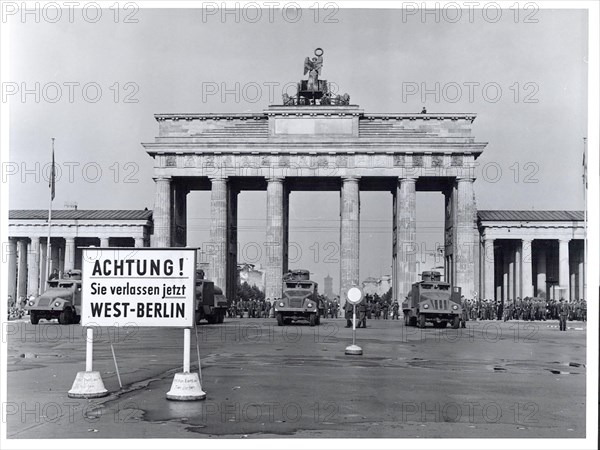 Original caption: East Berlin Put Behind Iron Curtain  Berlin, August 1961 - In a final attempt to halt a flood of refugees escaping from East Germany through West Berlin, the Communist Government of the Soviet Zone moved on August 13th to block off East Berlin with troops, road blocks and barbed wire. Heavily armed East German forces, backed up by Soviet army units, patrolled the East Sector to prevent disturbances while the free West Berliners, angered by the Communist action, demonstrated on their side of the border in sympathy with those now cut off from any contact with the West.  Military water trucks, with high-pressure hoses mounted in their turrets, are lined up in lead position along the Brandenburg Gate border. Behind are East Berlin soldiers and armored cars. The water trucks doused some West Berlin photographers who approached too close.