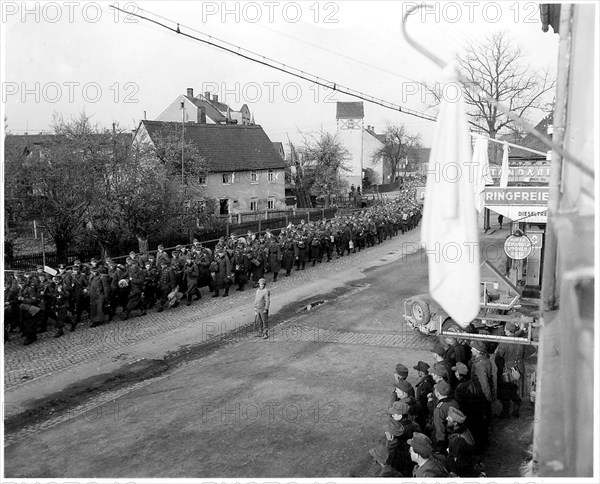 Original Caption: Surrender flag flies from civilian home in Chemnitz as more thousands of Nazi prisoners seized by the armored division of General Patton's Third Army marched to rear. 4th Armed Division.