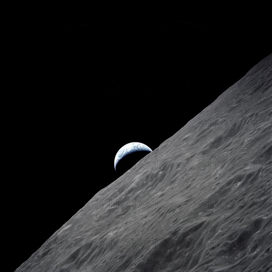 The crescent Earth rises above the lunar horizon