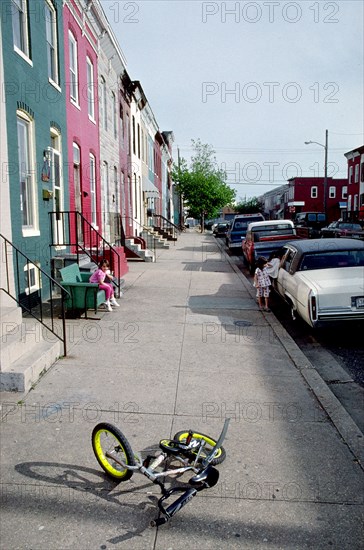 June 11, 1998 - small bike lying on sidewalk in urban neighborhood