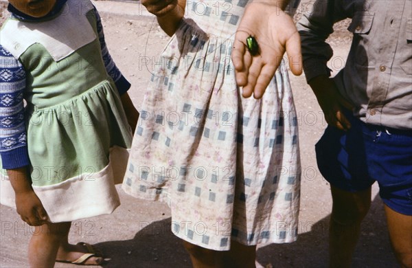 A girl has a beetle on a string in Cana Israel