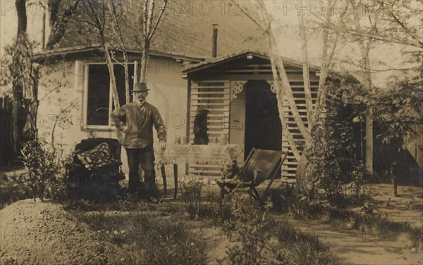 Man In A Hat In The Garden In Front Of His House