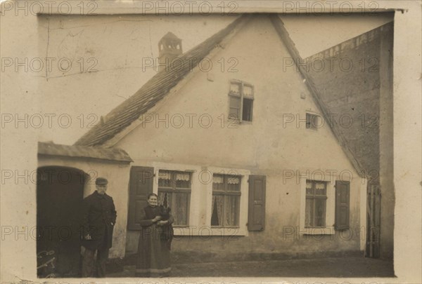 Elderly Couple In Front Of Their Family Home