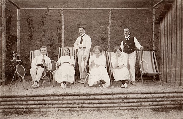 Three tennis couples posing on lounge chairs.