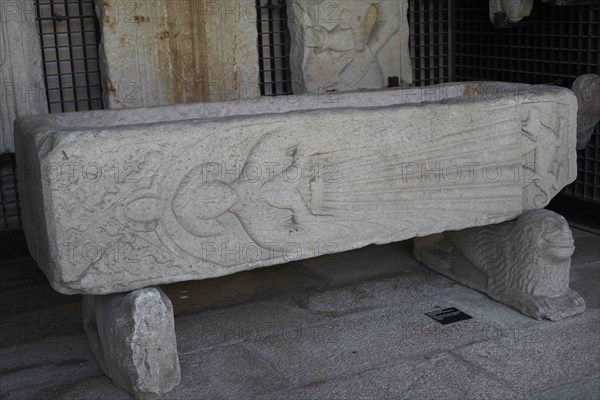 Stone tomb with depiction of a recumbent female figure and a dog in bas-relief