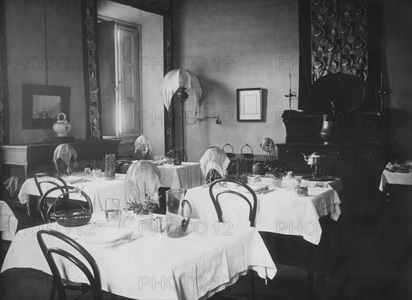 c'est dans ces années que les vacances à la montagne deviennent populaires et que, à côté des grands hôtels pour l'élite, naît la "pensione" pour les classes petites et moyennes. la photographie montrant la salle à manger d'une pensione à radicofani, sur les pentes de l'amiata, date de 1925