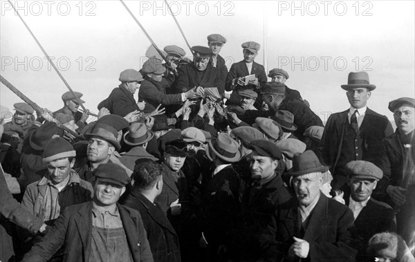 sur le pont avant du conte verde un groupe d'émigrants autour de l'aumônier. 1915-40