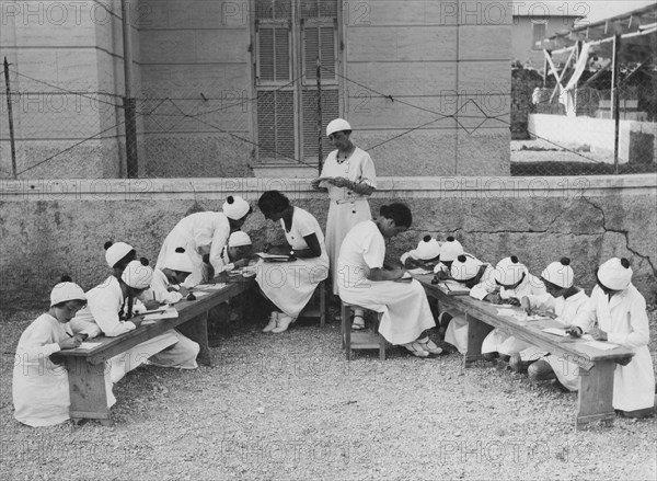 la lettre aux parents : un moment, reconstitué pour l'objectif du photographe, de la vie dans les colonies. 1915-1940