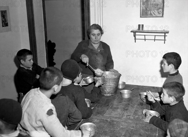 italy, summer camp, housekeeper serving the dinner at the refectory, 1946