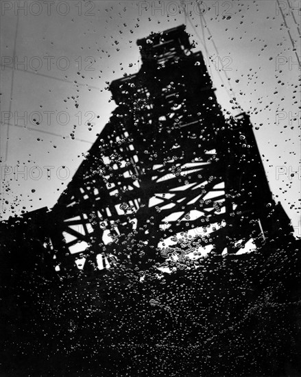 amérique, californie, un derrick reflété dans du pétrole, 1920