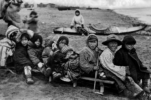 amérique, alaska, enfants eskimo jouant avec un traîneau sur le sable, 1910 1920