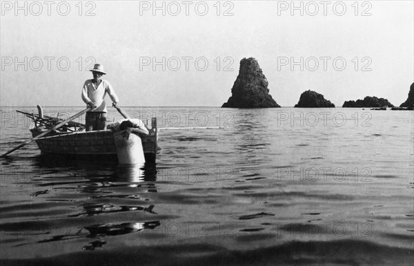 europe, italie, sicile, aci castello, pêcheurs près des îles cyclopes, 1950