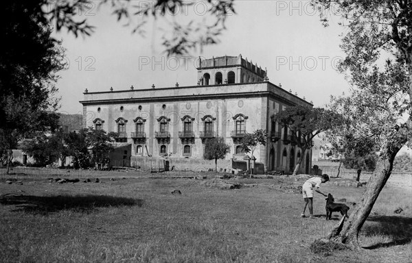 europa, italie, sicile, palerme, bagheria, petit garçon jouant dans le parc d'une villa, 1934