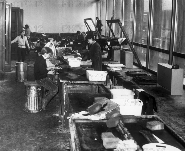 la restauration des livres après l'inondation du 4 novembre 1966, florence, toscane, italie, 1967