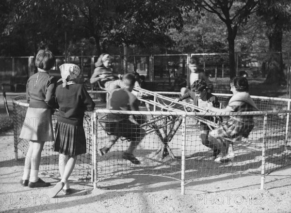 parc de milan, enfants jouant sur le manège, 1957