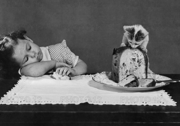 un chaton profite du sommeil de la petite fille, 1957