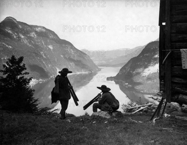 Two shepherds with old musical instruments made from roots. lake hallstatt. austria 1920