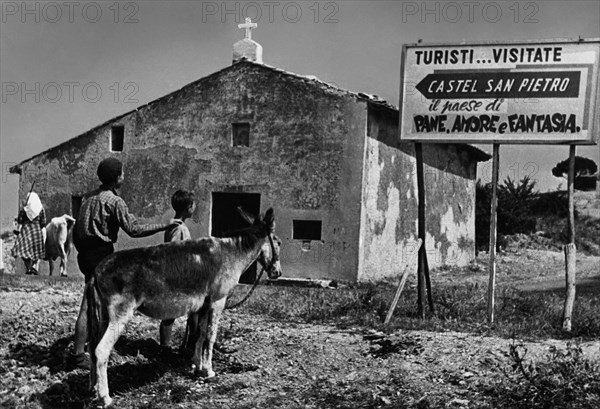 Italy. emilia romagna. entrance to the country castel san pietro. the town of bread. love and dreams. 1955