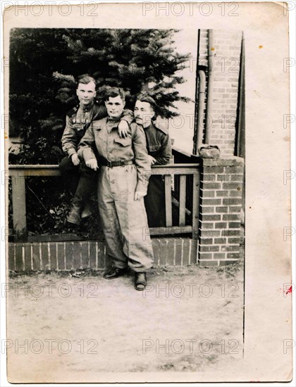 Group soldier of the Soviet Army posing near the house.