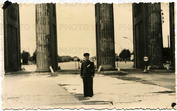 Captain of the Soviet Army in dress uniform standing between the columns of the Brandenburg Gate, Berlin.
