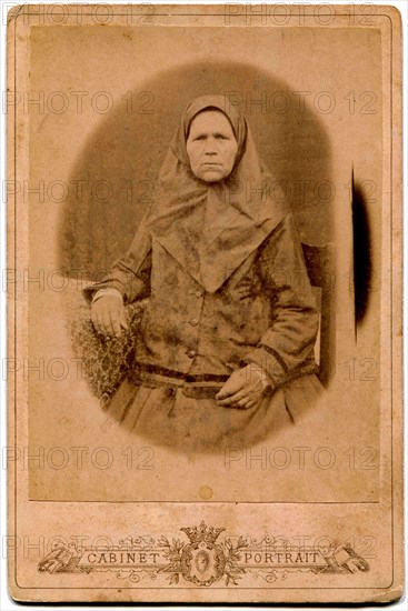 An elderly woman in a headscarf.