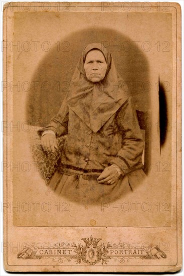 An elderly woman in a headscarf.